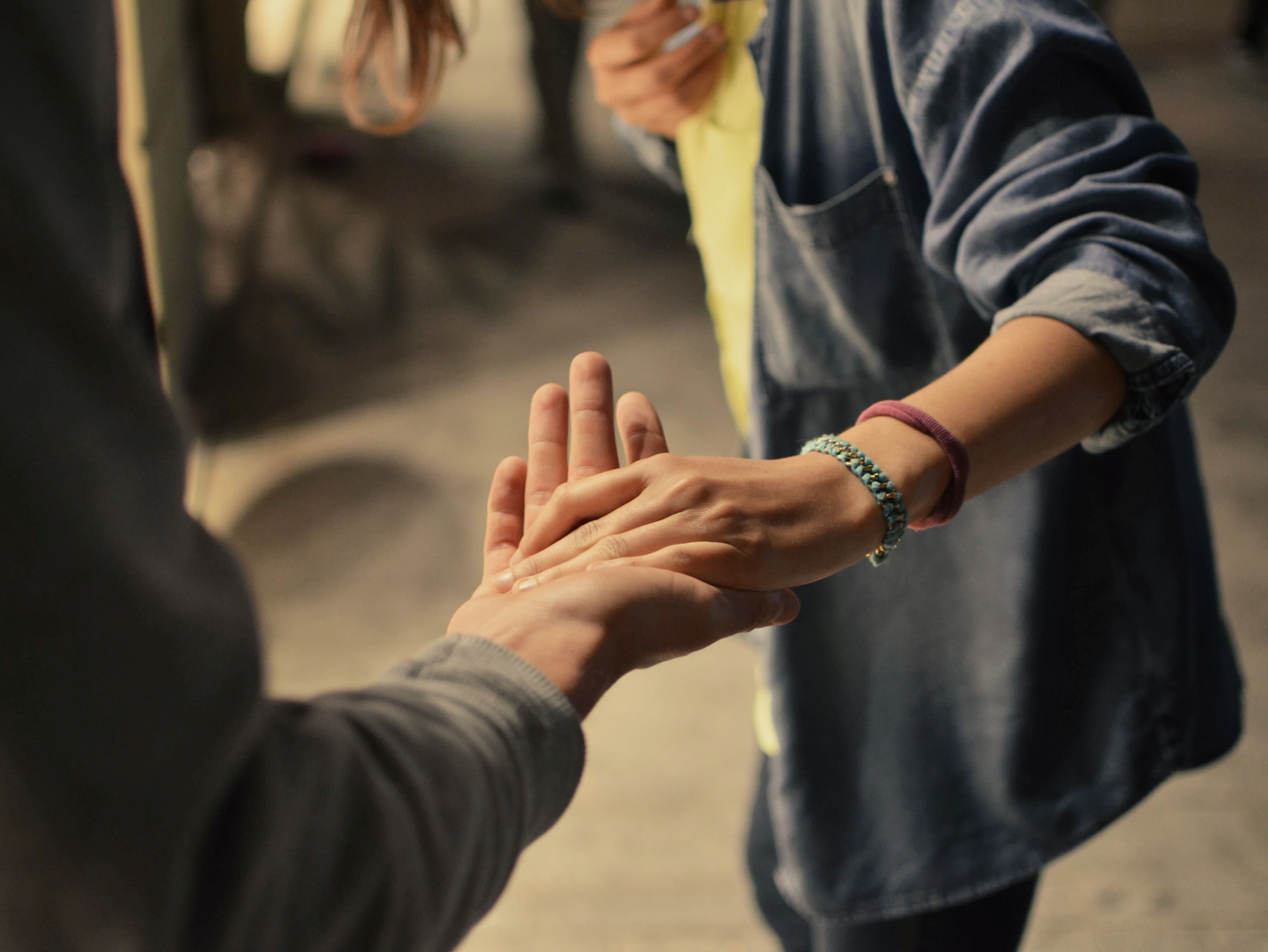 Nahaufnahme von zwei Händen, die sich sanft berühren.